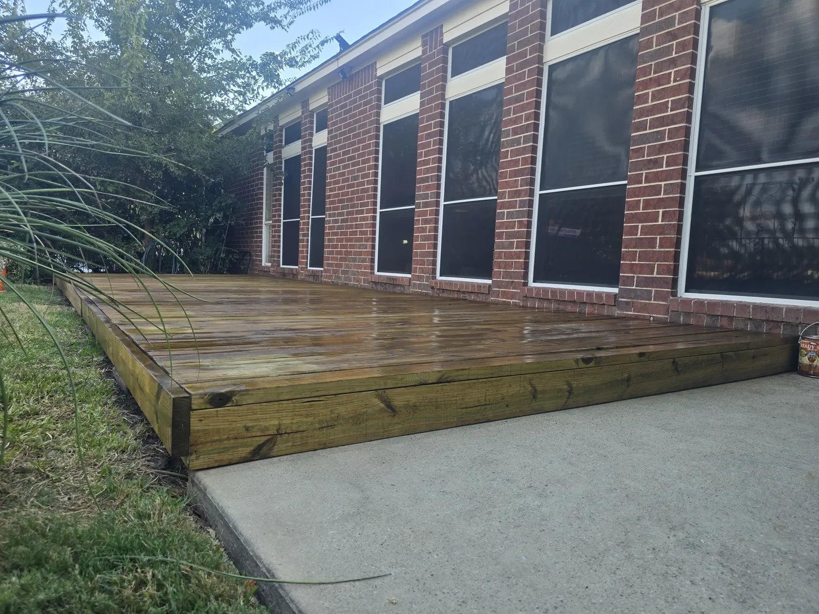 Freshly stained deck alongside a brick home in Mansfield, TX